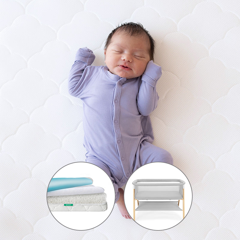 Baby sleeping on newton mattress with Newton waterproof mattress and essential bassinet in small circular cutouts.