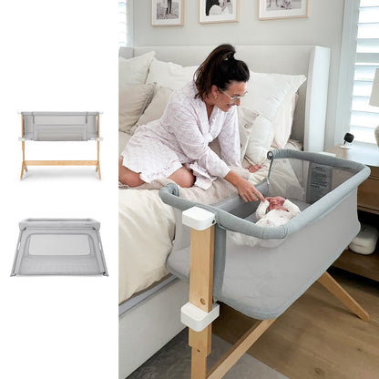 A woman in a pink robe reaches into the gray Newton Baby Bassinet & Bedside Sleeper + Deluxe Travel Crib with wooden legs by her bed, where a baby lies. On the left, two images show the portable crib folded and from the side.
