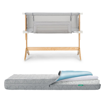 A Newton Baby Bundle 5 BFCM features a wooden-framed baby bassinet with light grey mesh sides placed above a grey patterned crib mattress with a removable top layer partially rolled back.
