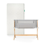 The Newton Baby Bundle 3 BFCM features a white washable crib mattress with a subtle patterned cover standing upright behind a gray breathable bassinet bedside sleeper with a light wooden frame.