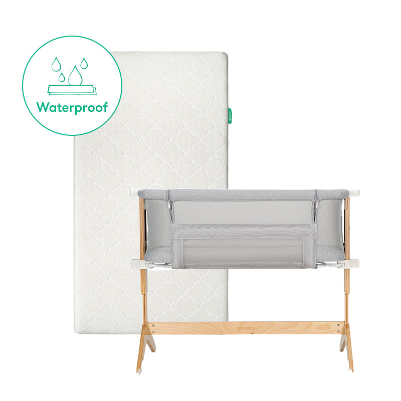 The Newton Baby Bundle 5 BFCM features a white waterproof baby mattress upright behind a gray mesh-sided bassinet with wooden legs. A green waterproof icon with water droplets is displayed near the mattress.