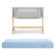 The Bundle 3 BFCM by Newton Baby features a wooden-framed, breathable bassinet with mesh sides, displayed above a light blue, quilted, washable crib mattress on a white background.