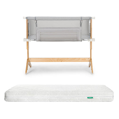 The Bundle 3 BFCM by Newton Baby includes a breathable bassinet with light grey mesh sides and a washable crib mattress with a subtle pattern and green tag, shown on a plain white background.