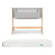 The Bundle 3 BFCM by Newton Baby includes a breathable bassinet with light grey mesh sides and a washable crib mattress with a subtle pattern and green tag, shown on a plain white background.