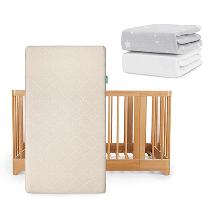 A Newton Baby Nest Convertible Crib with Original Mattress is propped upright, with two folded sheets—one gray with white stars and one solid white Breathable Organic Cotton Sheet—placed above and to the right.