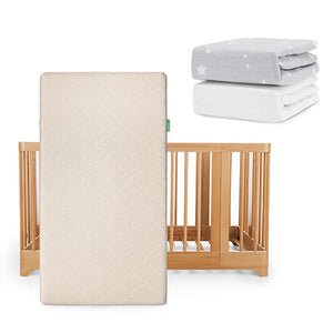 A Newton Baby Nest Convertible Crib with Original Mattress is propped upright, with two folded sheets—one gray with white stars and one solid white Breathable Organic Cotton Sheet—placed above and to the right.
