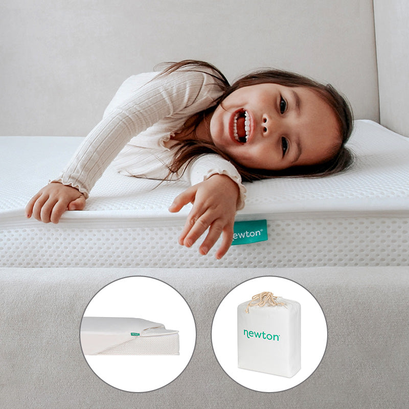A child lying on a Newton Baby Bundle 1 BFCM mattress.