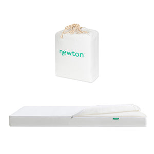 A white Newton Baby mattress with a slightly folded corner is displayed beneath a white drawstring bag labeled 