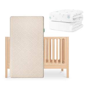 The Newton Baby Galileo Crib is featured with the Original Crib Mattress in front. To the right, two folded white Newton Baby sheets—one adorned with blue stars—are displayed. skip
