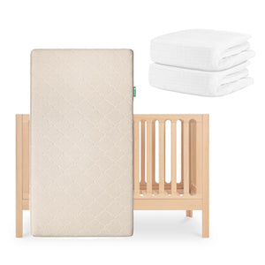 The Newton Baby Galileo Crib, paired with the Original Crib Mattress and two folded white Breathable Organic Cotton Sheets, is displayed on a white background. skip