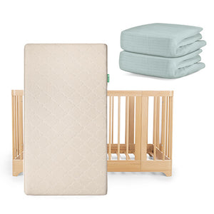 The Newton Baby Nest Convertible Crib, Original Mattress, and two folded light blue crib sheets—including a Breathable Organic Cotton Sheet—are displayed together.