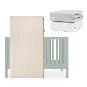 A light green Newton Baby Galileo Crib with an Original Crib Mattress in front. Above and right are two folded sheets: one gray with white stars and one plain white Breathable Organic Cotton Sheet. skip