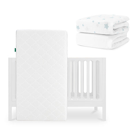 The Newton Baby Galileo Crib is shown with the Original Crib Mattress propped against it, plus two folded white crib sheets with blue star patterns—including a Breathable Organic Cotton Sheet—placed above to the right. skip