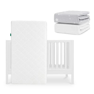 The Newton Baby Galileo Crib with the Original Crib Mattress stands upright, while two folded fitted sheets—a gray star-patterned and a Breathable Organic Cotton Sheet—are stacked nearby. skip