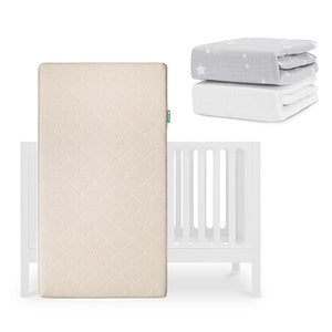 The Newton Baby Galileo Crib is shown with the Original Crib Mattress standing upright, and two Newton Baby crib sheets—one gray with white stars and one solid organic cotton—stacked in the upper right corner. skip
