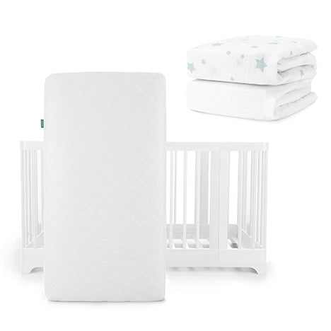 A white Newton Baby Original Mattress stands vertically before a Nest Convertible Crib, with breathable organic cotton sheets featuring light blue stars folded in the background.