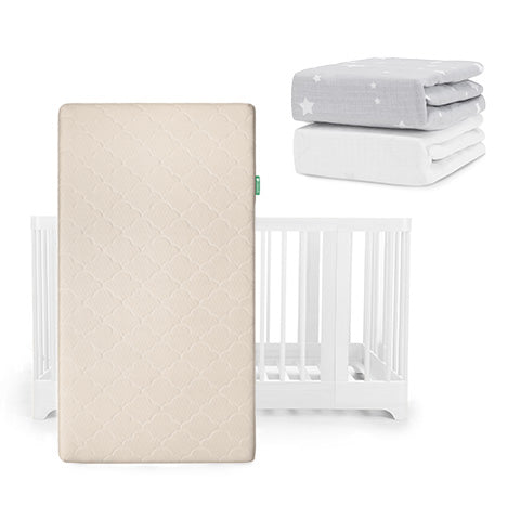 A beige Newton Baby Original Mattress stands upright before a Nest Convertible Crib, with two crib sheets—one light gray with white stars and one solid white Breathable Organic Cotton Sheet—stacked above.