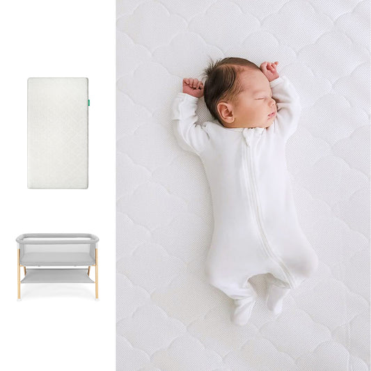 Newborn baby sleeping on a white mattress with a white crib and white pillow displayed next to it. 1000-wht-8402 