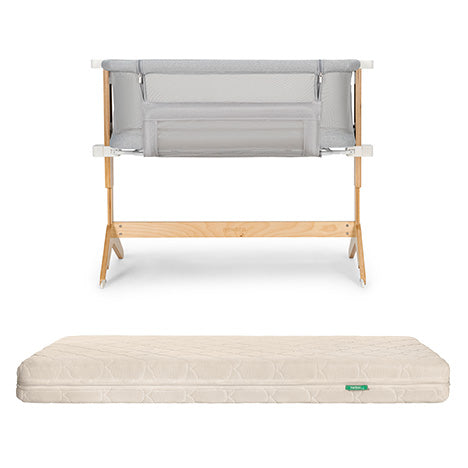 The Newton Baby Bassinet & Bedside Sleeper with light gray mesh is paired with the Original Crib Mattress, which features a cream-colored, patterned cover.
