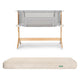 The Newton Baby Bassinet & Bedside Sleeper with light gray mesh is paired with the Original Crib Mattress, which features a cream-colored, patterned cover.
