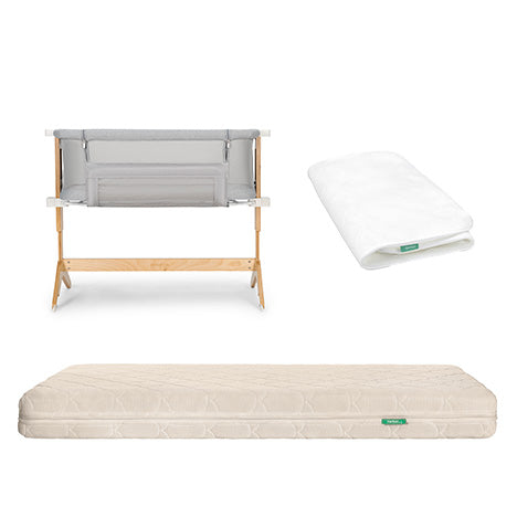 The Newton Baby Bedside Sleeper features a wooden frame, grey sides, a folded white sheet, and includes the Original Crib Mattress with Waterproof Pad, all displayed on a white background.
