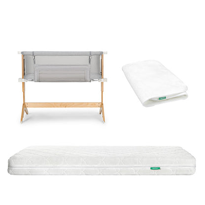 The Newton Baby Bundle 6 BFCM includes a wooden bassinet with a gray fabric side, a folded white fitted sheet, and a subtly patterned white mattress, all displayed on a white background.