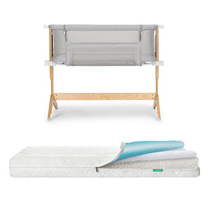 The Newton Baby Bundle 5 BFCM includes a wooden-framed bedside bassinet with mesh sides, displayed above a layered crib mattress. A flipped corner reveals the mattress’s different inner layers of foam and fabric.