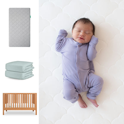 A newborn in a lavender onesie sleeps on the Newton Baby Galileo Crib with the Original Crib Mattress & Sheets. To the left are images of the 3-in-1 convertible crib, two breathable organic cotton sheets, and a wooden crib. 111-8420-CST-1000-GRY-SNS
