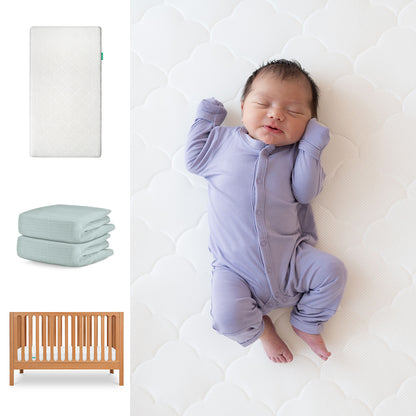 A baby in a lavender onesie sleeps on the Newton Baby Galileo Crib with the Original Crib Mattress and Sheets. Nearby are images of the 3-in-1 convertible crib, two folded breathable organic cotton sheets, and a wooden crib. 111-8420-CST-1000-WHT-SNS
