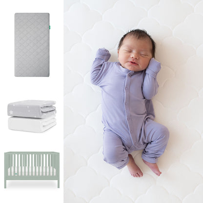 A newborn in a lavender onesie sleeps on the Newton Baby Galileo Crib with the Original Crib Mattress and Sheets. On the left are images of a gray mattress, two folded organic cotton sheets, and the light green 3-in-1 Galileo Crib. 111-8420-SGE-1000-GRY-SGW
