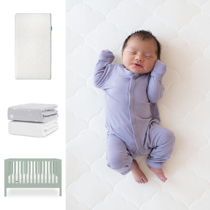 A baby in a lavender onesie sleeps on the Newton Baby Galileo Crib with the Original Crib Mattress & Sheets. To the left are images of the mattress, star-patterned blankets, and the light green 3-in-1 convertible crib. 111-8420-SGE-1000-WHT-SGW
