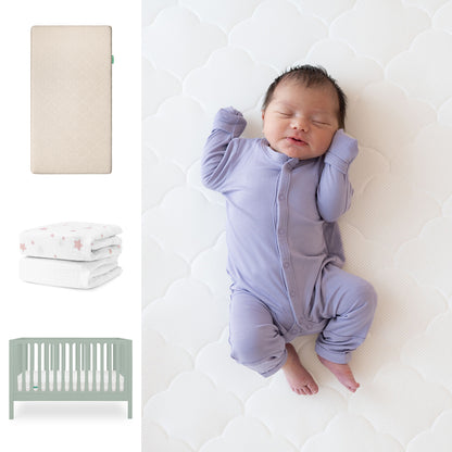 A newborn in a lavender onesie sleeps on the Newton Baby Galileo Crib with the Original Crib Mattress. On the left are Newton Baby organic cotton sheets, two star-patterned crib sheets, and a light green 3-in-1 convertible crib. 111-8420-SGE-1000-SAN-PSW
