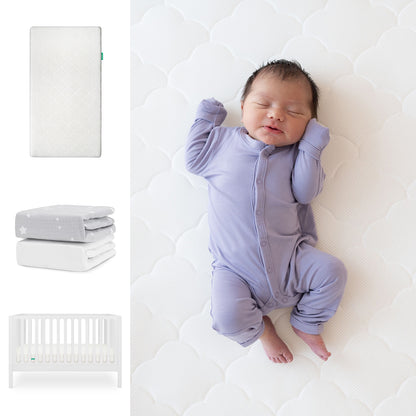 A newborn in a lavender onesie sleeps on the Newton Baby Galileo Crib with the Original Crib Mattress & Sheets. Nearby are images of the crib, mattress, two blankets, an organic cotton sheet, and more. 111-8420-WHT-1000-WHT-SGW
