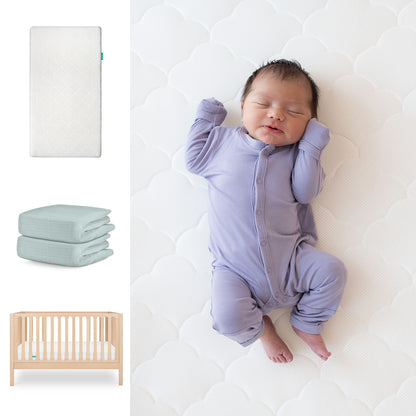 A baby in a lavender onesie sleeps on the Newton Baby Galileo Crib with the Original Crib Mattress & Sheets; nearby are images showing its 3-in-1 convertible design, folded organic cotton sheet, and wooden frame. 111-8420-NAT-1000-WHT-SNS

