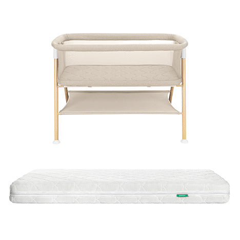 The Newton Baby Essential Bassinet with wooden legs and lower storage shelf is paired with the Original Crib Mattress, displayed on a plain white background.