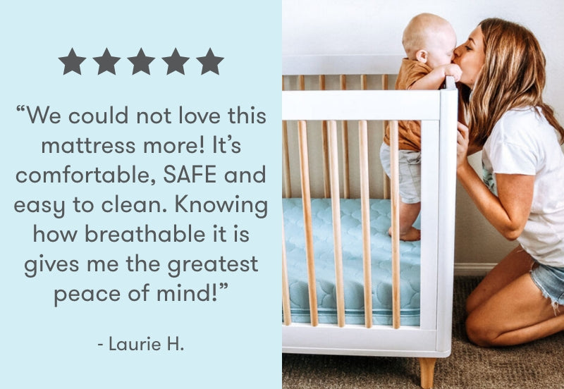 A mother kisses her baby who is standing in a crib, with a testimonial saying, "We could not love this mattress more! It's comfortable, SAFE and easy to clean. Knowing how breathable it is gives me the greatest peace of mind!" - Laurie H., accompanied by five stars.