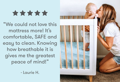 A mother kisses her baby who is standing in a crib, with a testimonial saying, "We could not love this mattress more! It's comfortable, SAFE and easy to clean. Knowing how breathable it is gives me the greatest peace of mind!" - Laurie H., accompanied by five stars.