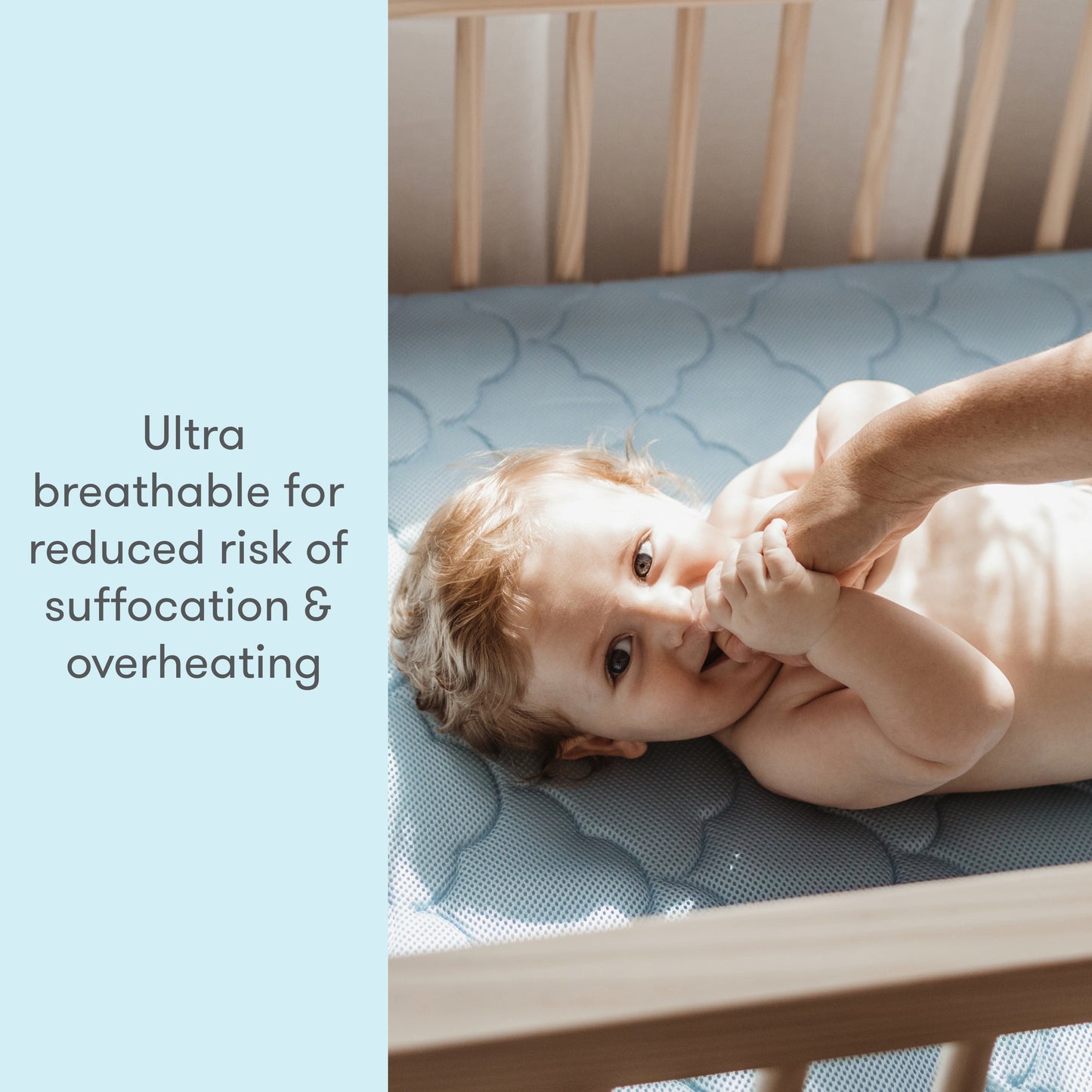 Image of a baby wearing a cute outfit, lying on a mattress, with text stating "Ultra breathable for reduced risk of suffocation & overheating."