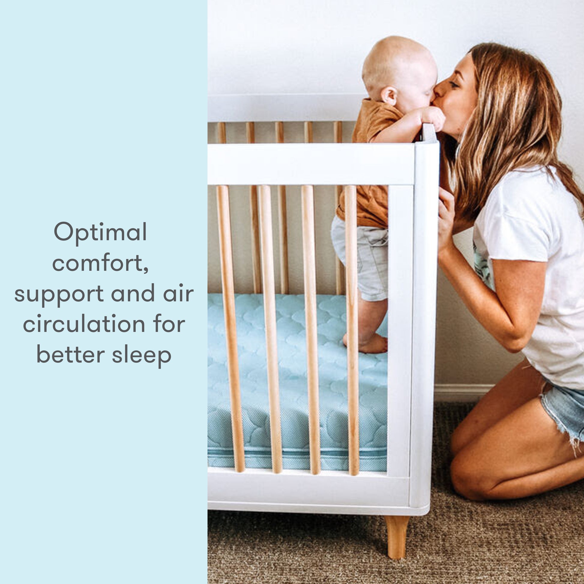 mother holding baby and kissing it while baby stands on blue newton mattress with text "optimal comfort support and air circulation for better sleep"