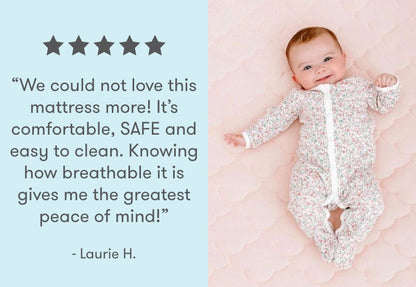 A smiling baby lying on a pink breathable mattress with a customer review saying "We could not love this mattress more! It's comfortable, SAFE and easy to clean. Knowing how breathable it is gives me the greatest peace of mind!" - Laurie H., and five stars rating above the text.
