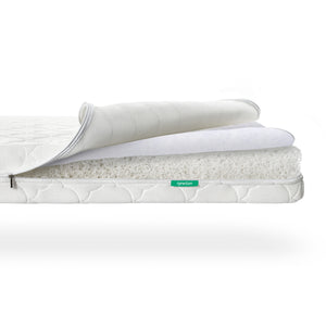 A Newton Baby Crib Mattress with the cover partially unzipped to reveal layers of breathable, white, web-like material.