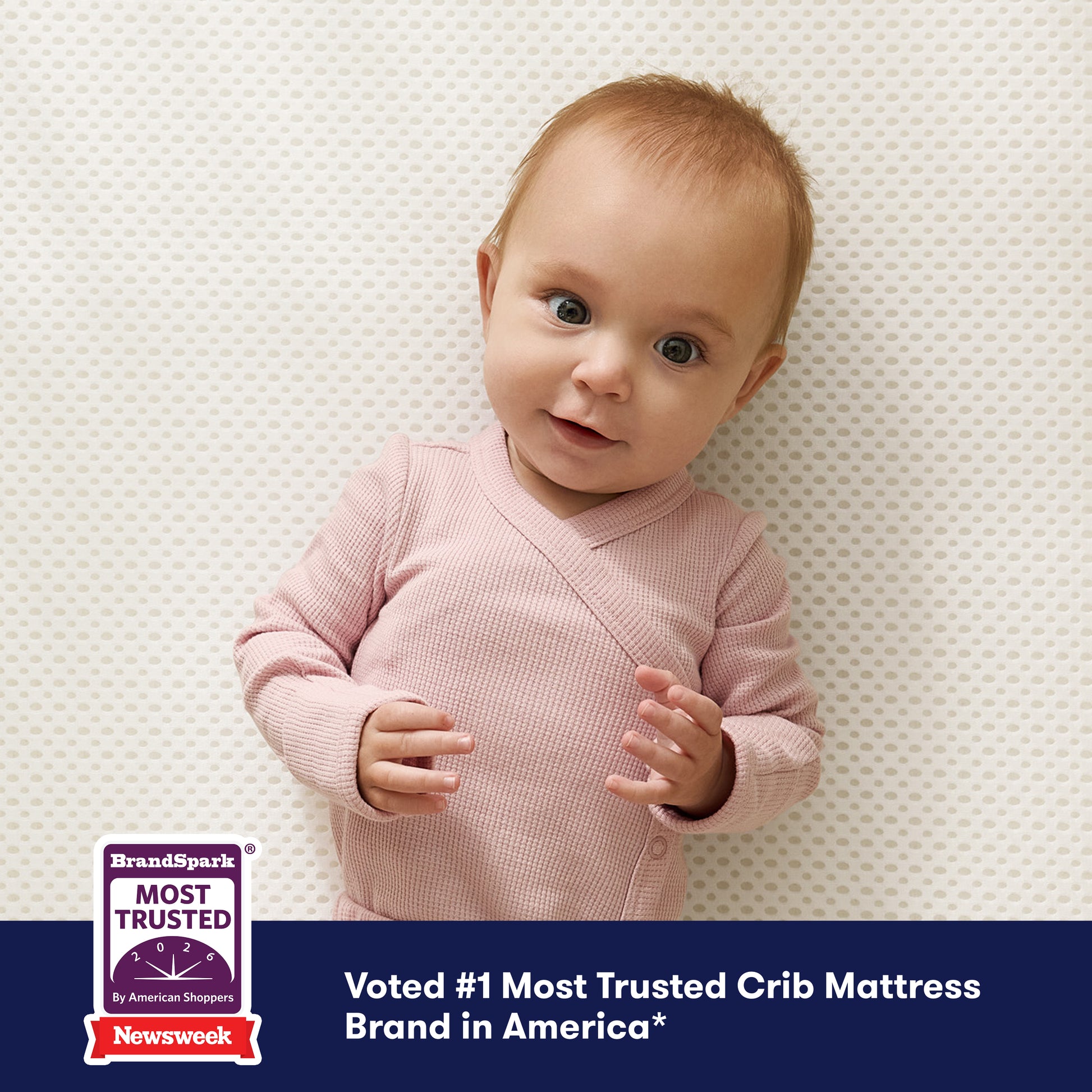 A baby in pink lies on the Newton Baby Essential Crib Mattress, smiling. A bottom banner reads, Voted #1 Most Trusted Crib Mattress Brand in America with BrandSpark and Newsweek trust badges.