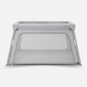 The Travel Crib & Play Yard is a gray portable crib with mesh sides and a soft, padded frame for comfort. This breathable play yard is shown on a plain white background.
