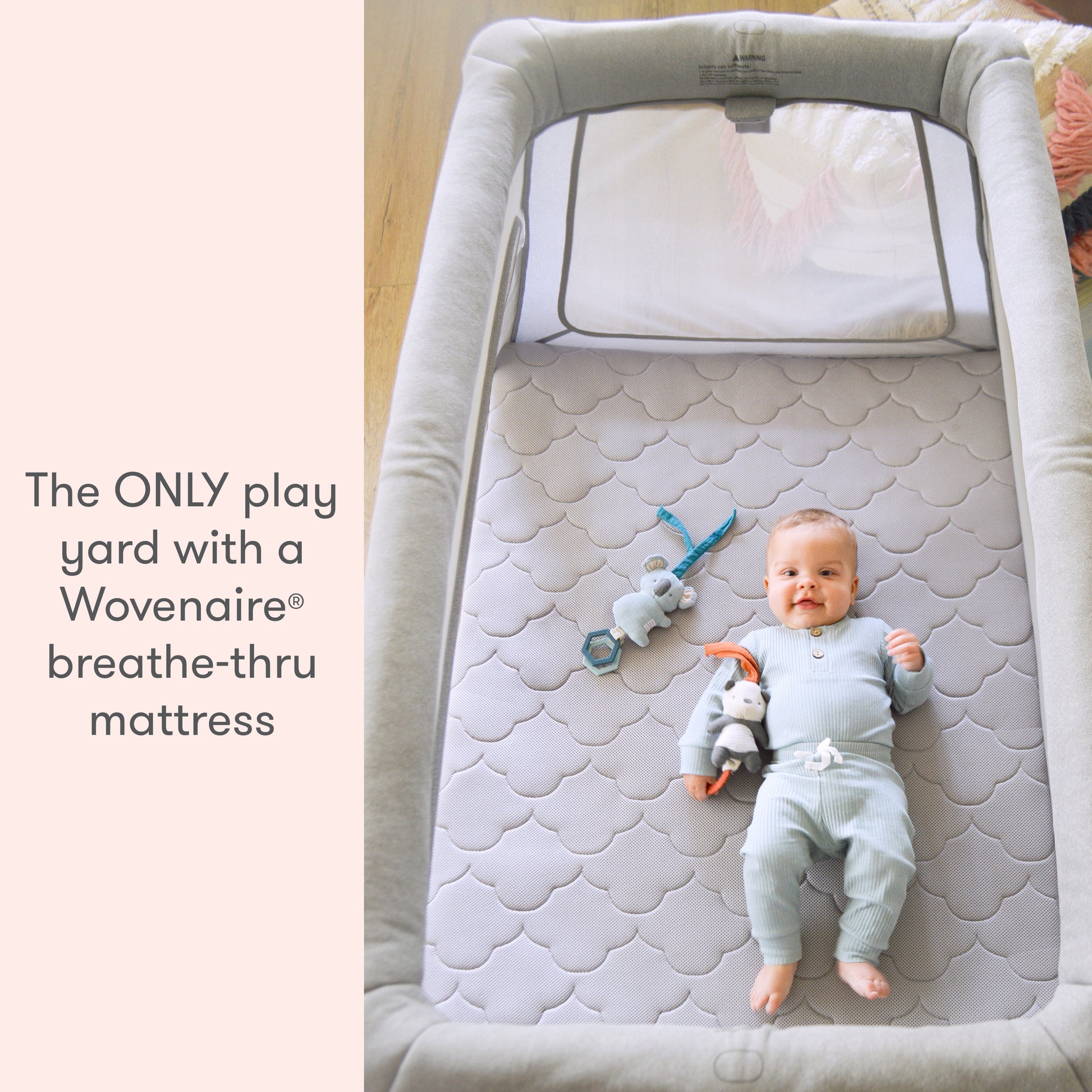 baby lying on floor mattress with toys in newton travel crib and play yard with text "the ONLY play yard with a Wovenaire breathe-thru mattress"