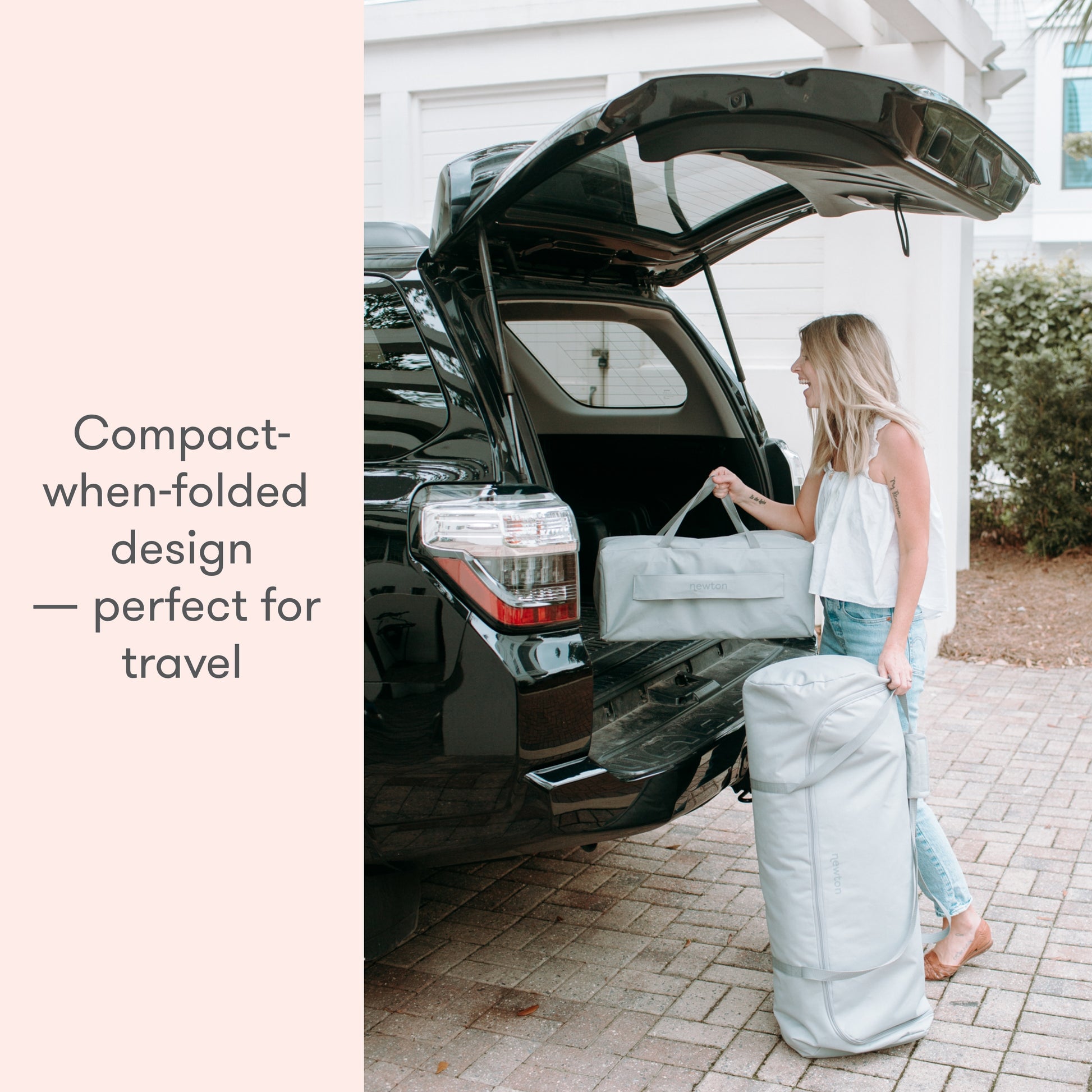 woman standing next to car with newton play yard packed up in carry bad with text "compact when folded design -- perfect for travel"