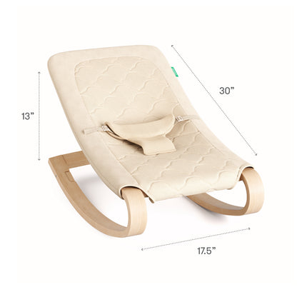 The Newton Baby Rocker is beige and quilted with wooden curved legs, measuring 30" L x 17.5" W x 13" H. It features a breathable seat cover and a small harness to secure your baby.