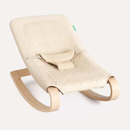 Beige baby rocker with quilted cover on a white background