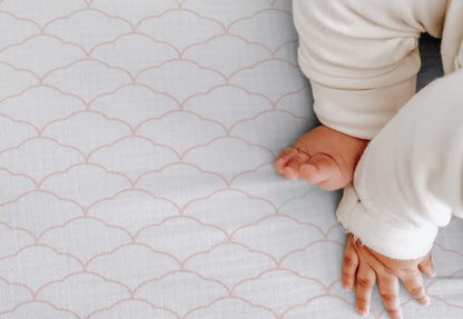 Baby's feet and hands on a soft cloud patterned sheet designed for comfortable and safe infant sleep. 999-3020-PDW 999-3520-PDW