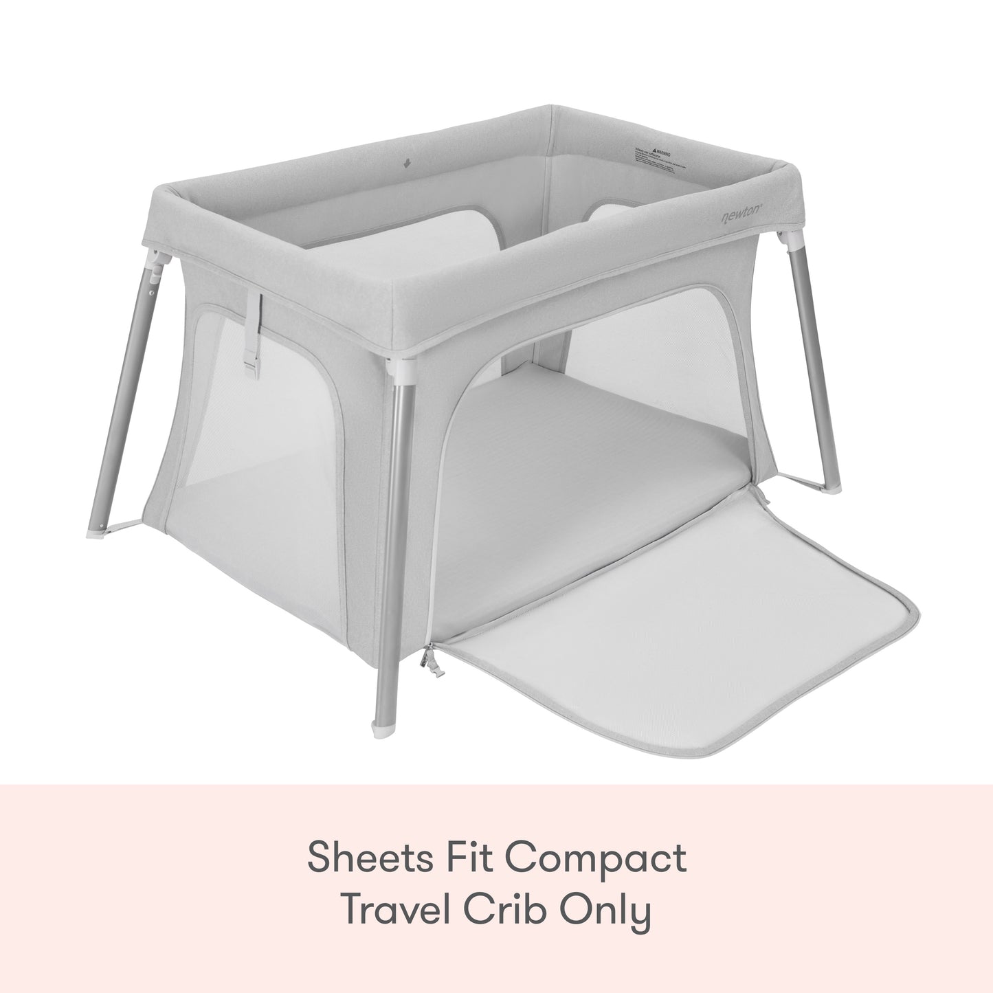 A Newton Baby Compact Travel Crib with light gray mesh sides and a zippered panel. Text below: Compact Travel Crib Sheets by Newton Baby fit this model only.