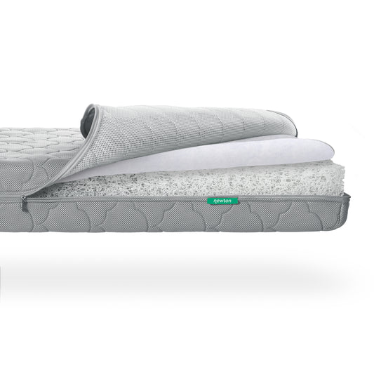 Cross-section of a Newton Baby Crib Mattress showing layers including a fibrous, washable inner core. skip